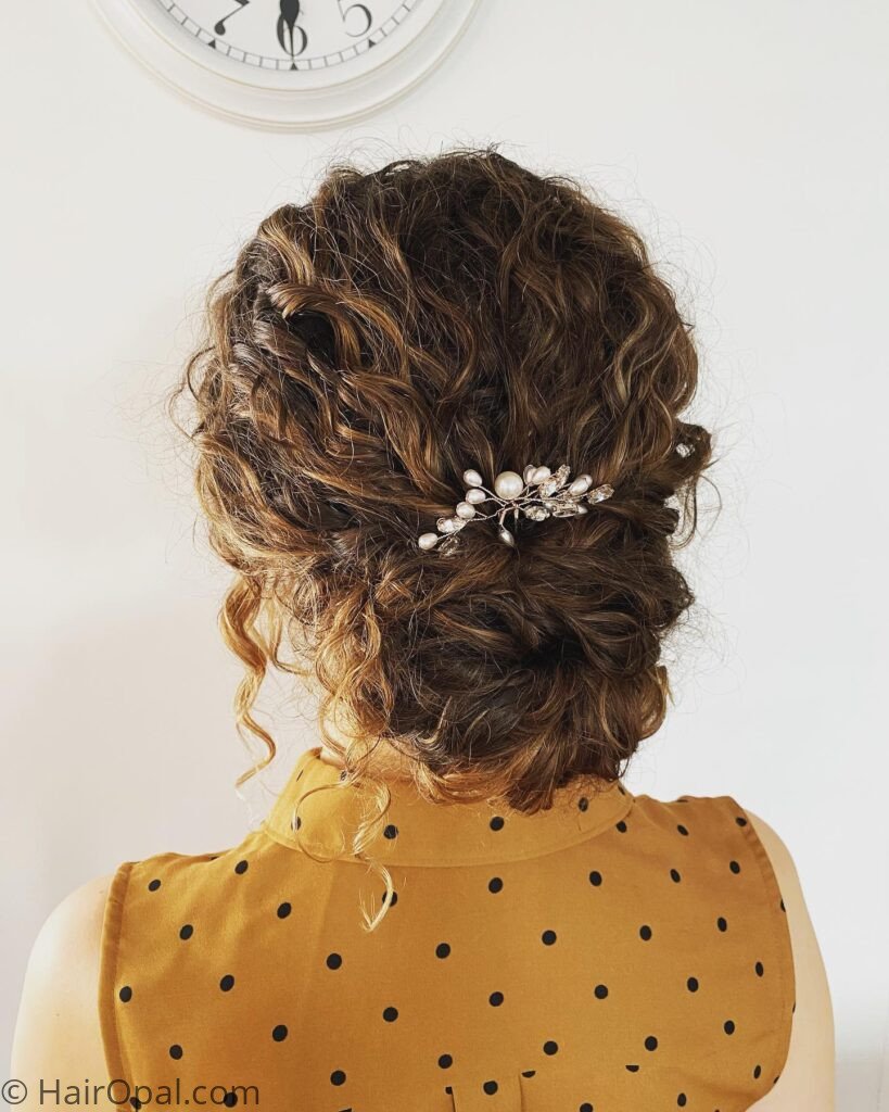 Curly hair styled in a half-updo with small star hair clips